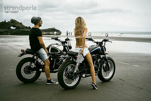 Stilvolles Paar auf Motorrädern am Meeresstrand. Bali.