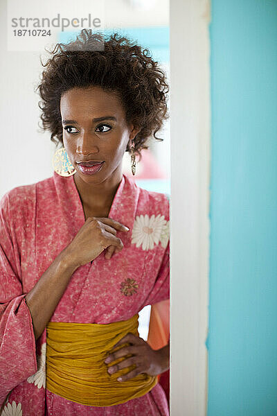 Ein Model  fotografiert während eines Lifestyle-Shootings  das in einem Kimono in einer Tür steht  Minneapolis  Minnesota.