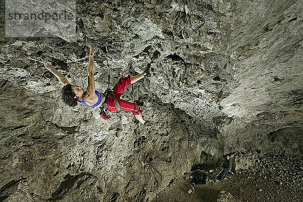 Eine Frau mittleren Alters beim Klettern in der Actopan-Höhle  Hidalgo  Mexiko.