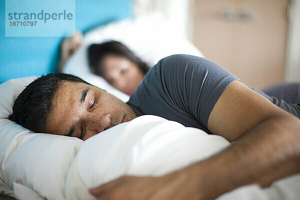 Ein Mann und eine Frau schlafen im Bett.
