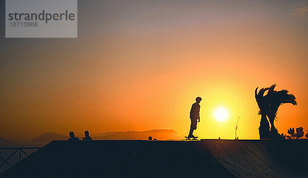 Eine Gruppe Jungen auf Skateboard im Sommer  Silhouette nicht wiederzuerkennen.