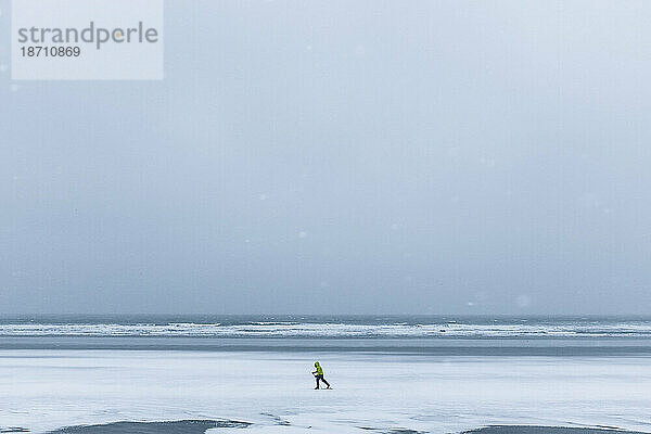 Ein einsamer Skifahrer bahnt sich seinen Weg über einen zugefrorenen Strand in York  Maine