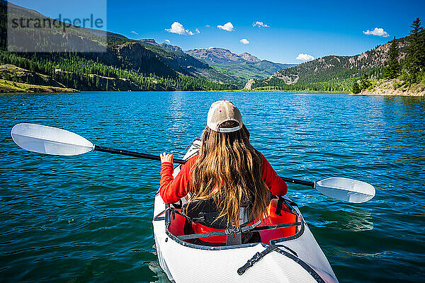 Frau fährt Kajak im blauen Wasser des San Cristobal-Sees