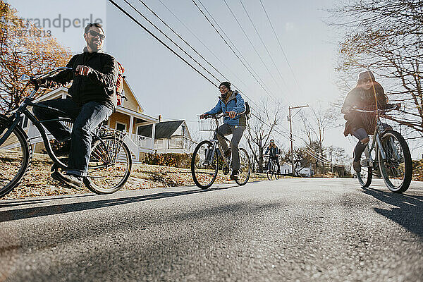 Eine Gruppe von vier Freunden fährt mit dem Fahrrad durch ein Dorf in Maine