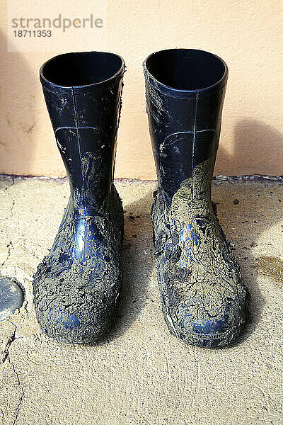 Schlammige Gummistiefel vor einer Hütte in Costa Rica.