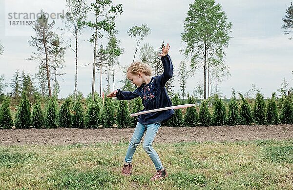 Junges Mädchen spielt in ihrem Garten mit einem Hula-Hoop-Reifen