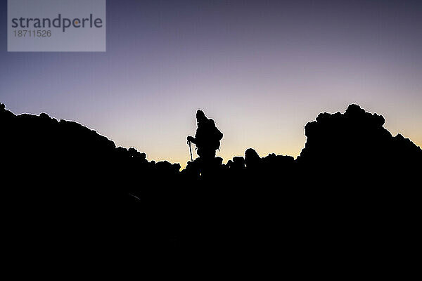 Ein Wanderer beobachtet den Sonnenaufgang auf dem Gipfel des Vulkans El Teide
