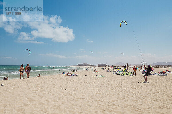 Landschaft eines Strandes mit Kitesurfern und Menschen  die Spaß haben