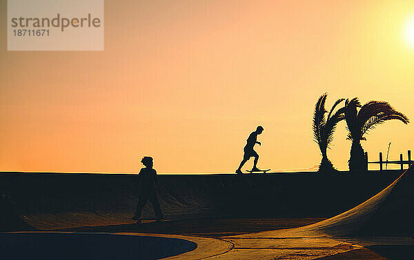 Eine Gruppe Teenager auf Skateboard im Sommer  Silhouette nicht wiederzuerkennen.