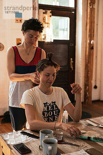 Queeres Paar genießt Friseursalon in schönem Holzhaus