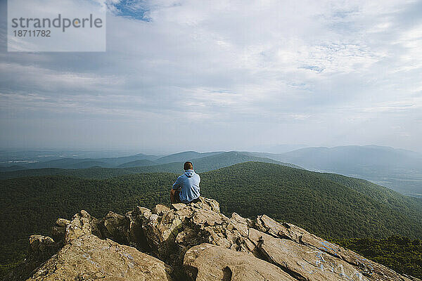 Ein junger Erwachsener blickt auf eine weite Bergkette in Virginia.