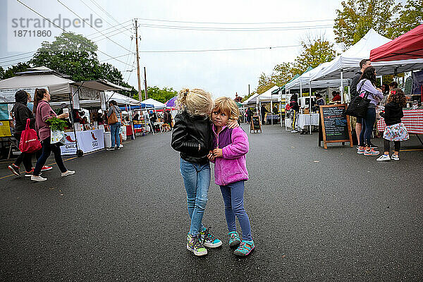 Zwei Mädchen stehen im Herbst zusammen auf dem Bauernmarkt