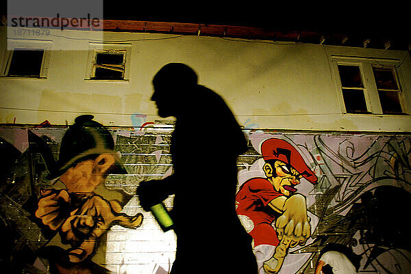 Silhouette eines Künstlers geht an einer Graffitiwand in Austin  Texas vorbei.