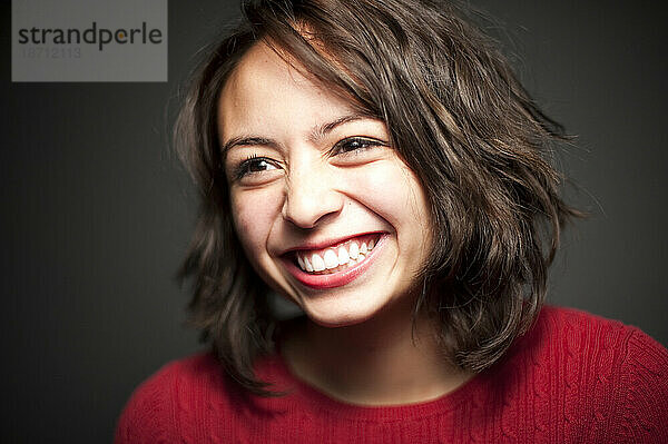 Studioporträt eines 15-jährigen Latina-Mädchens  das lacht.