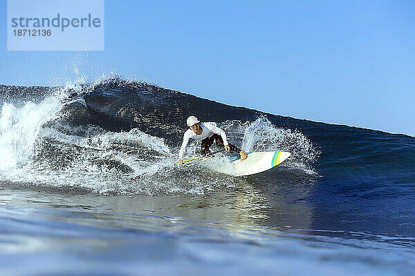 Weibliche Surferin reitet Welle