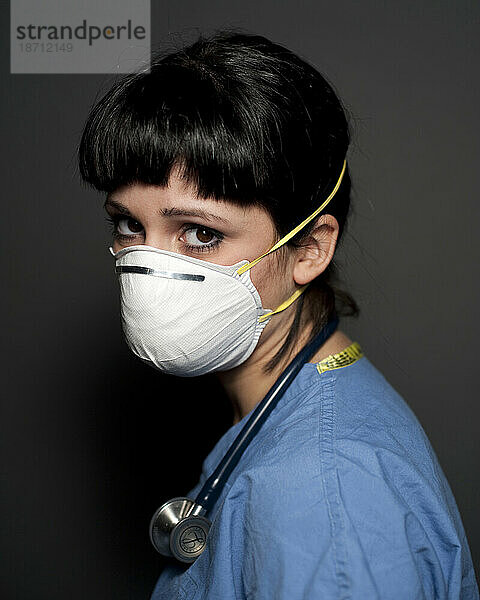 Studioporträt einer 25-jährigen kaukasischen Frau  die eine N95-Maske und ein Stethoskop trägt.