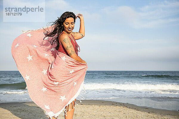 Latina-Frau vergnügt sich mit Handtuch am Strand