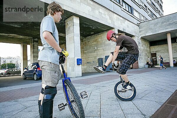 Teenager demonstriert einen Einrad-Trick