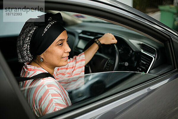 Asiatische Frau fährt Auto