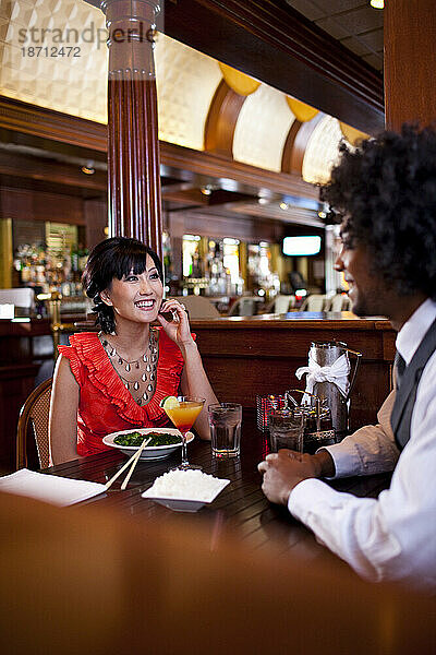 Ein Mann und eine Frau genießen eine asiatische Fusionsmahlzeit in einem Restaurant im Nordosten von Minneapolis  Minnesota.