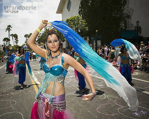 Bei einer Parade in Santa Barbara tanzt ein Harem die Straße hinauf. Die Parade umfasst extravagante Festwagen und Kostüme.