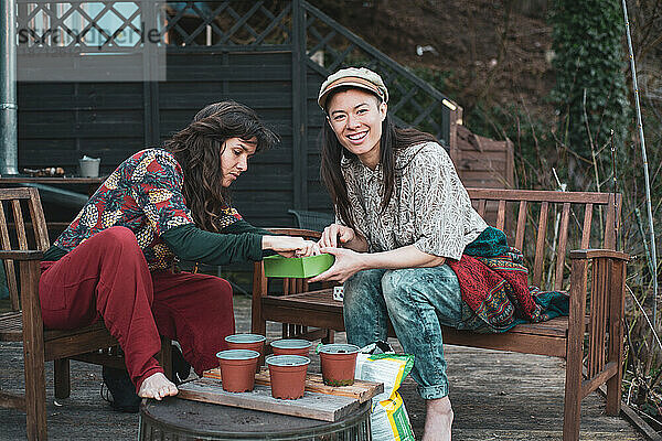 Zwei Frauen gärtnern im Frühling neue Setzlinge an Deck