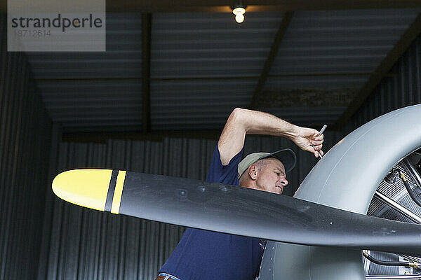 Flugzeugmechaniker und Pilot  der an seinem SNJ-5 Navy-Jagdflugzeugtrainer aus dem Zweiten Weltkrieg arbeitet.