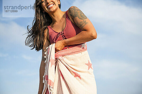 Latina-Frau vergnügt sich mit Handtuchwickel am Strand