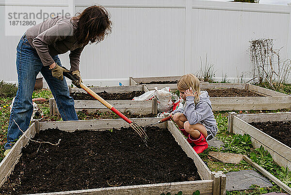 Frau und Kind kümmern sich um den Garten