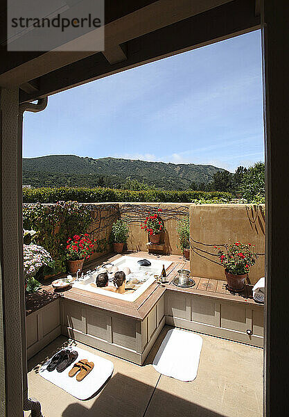 Ein Paar entspannt sich im Außenwhirlpool einer Lodge im kalifornischen Carmel Valley.