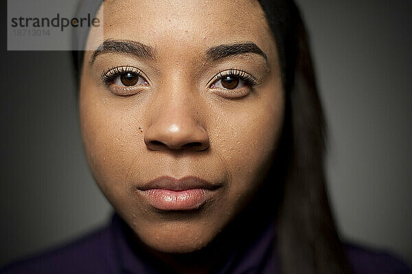 Studio-Nahaufnahmeporträt einer 21-jährigen afroamerikanischen Frau.