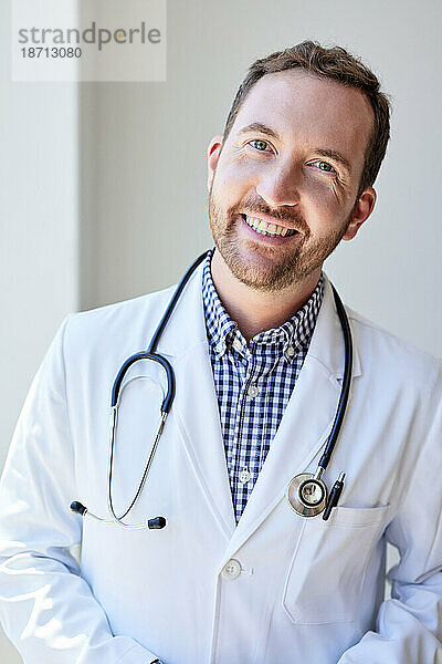 Porträt eines glücklichen männlichen Gesundheitspersonals mit Stethoskop in der Klinik
