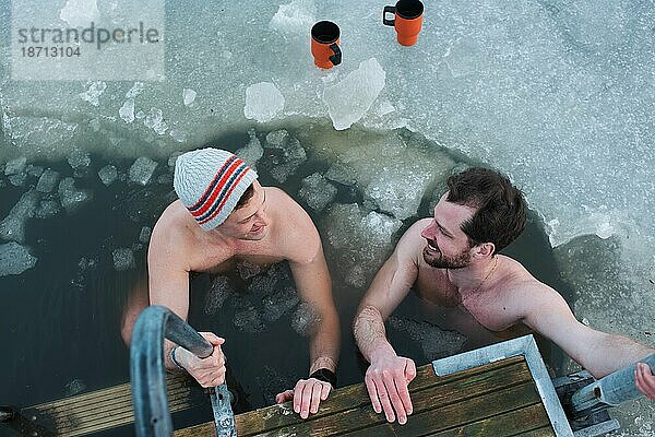 Zwei männliche Freunde nehmen ein kaltes Wasserbad in der Ostsee