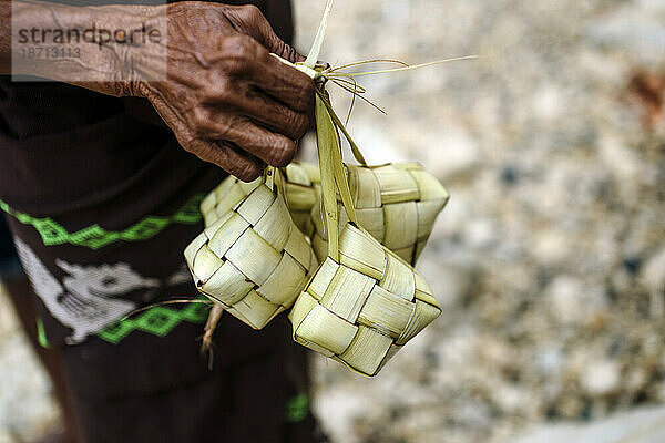 Hand mit traditionellen Reiskörben  Insel Sumba  Indonesien