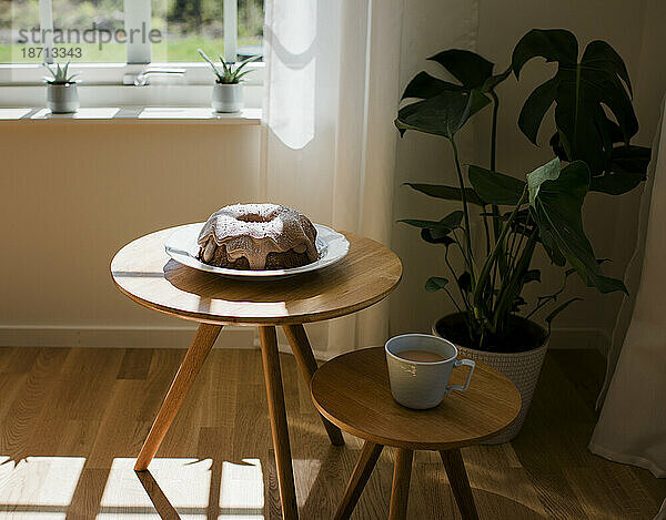 Hausgemachter Schokoladenkuchen und eine Tasse Tee auf einem Holztisch
