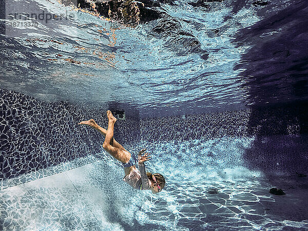Junges Mädchen springt an einem heißen Sommertag in den Pool