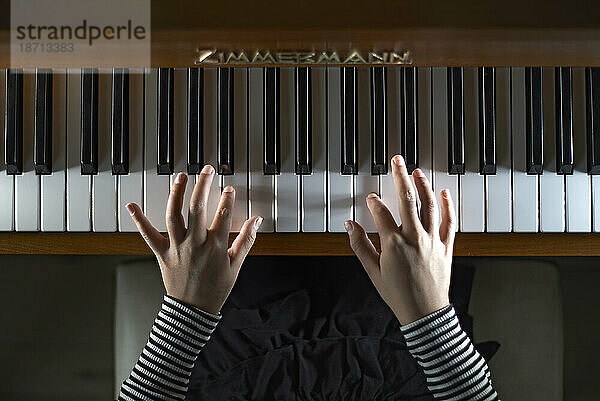 Nahaufnahme von Händen  die Klavier spielen und sich über die Tastatur bewegen