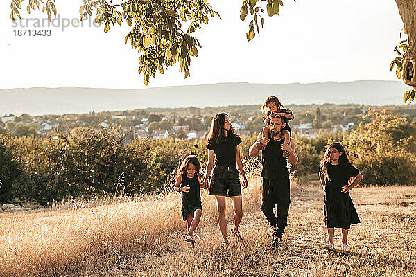 Glückliche Familie Drei Töchter  Vater und Mutter  gehen auf dem Land in der Natur spazieren