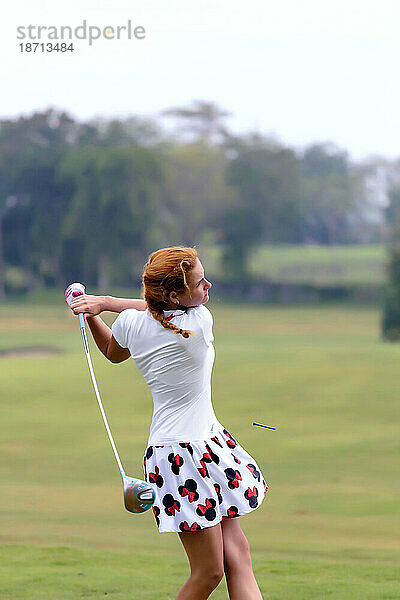 Frau im Rock spielt Golf