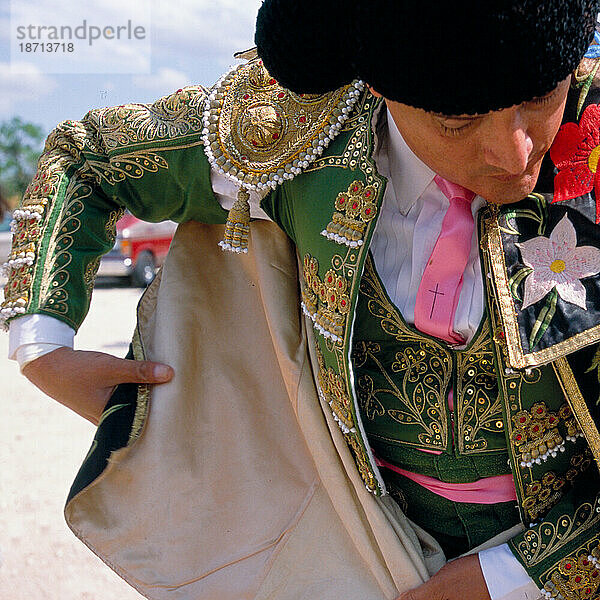 Ein Matador hüllt sich in seinen Paradeumhang  bevor er die Stierkampfarena Santa Maria betritt.