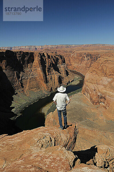 Ein Mann am Horseshoe Bend mit Blick auf den Colorado River in der Nähe von Page  Arizona  USA
