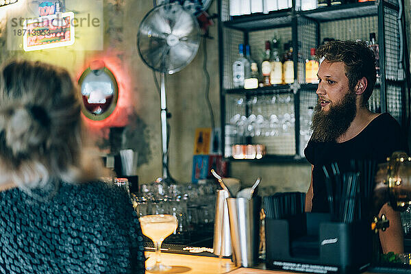 Barkeeper und Kunde in einer Cocktailbar.