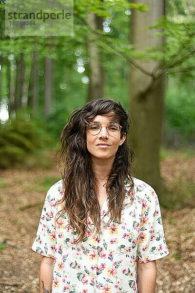 Natürliches Porträt einer Frau  die friedlich im grünen Wald Europas lächelt