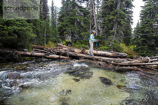 Mittellange Ansicht von Frauen  die über einen Fluss in British Columbia wandern.