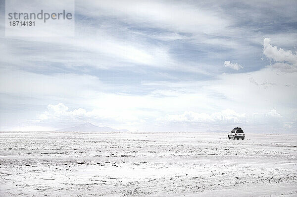 Auto inmitten einer riesigen Salzwüste in Bolivien