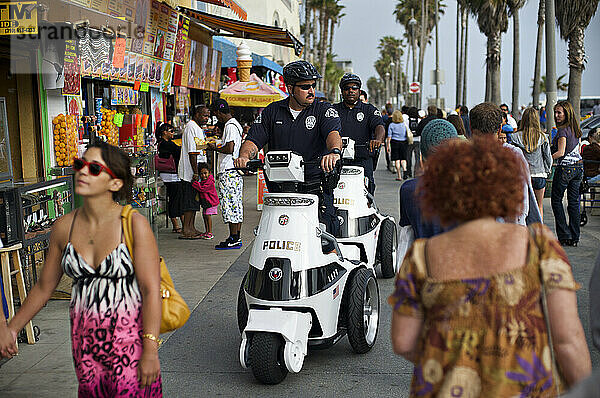 Polizisten patrouillieren auf maßgeschneiderten Segway-Rollern auf dem Venice Boardwalk in Los Angeles.