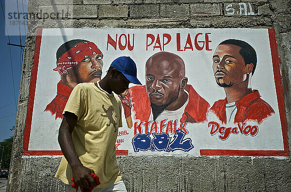 Ein Mann geht an einem Wandgemälde vorbei  das den verstorbenen Mitgliedern der Rap-Kreyol-Gruppe Barikad Crew in Port-au-Prince  Haiti  gewidmet ist.