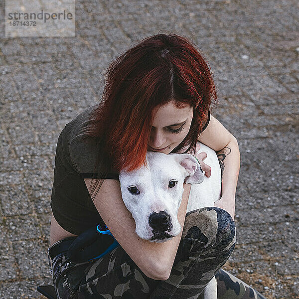 Die Frau umarmt ihren Hund – Dogo Argentino