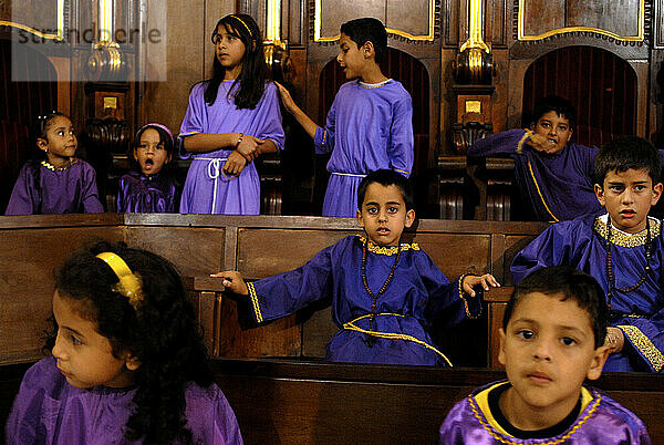In Merida  Venezuela  besuchen Kinder in traditionellen lila Gewändern die Messe der Karwoche.