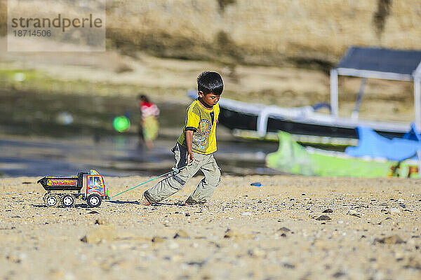 Asiatischer Junge spielt am Strand. Insel Lombok. Indonesien.